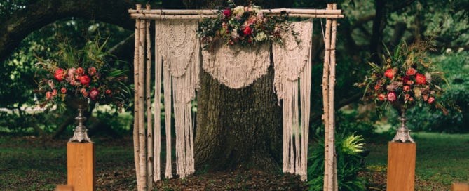 audubon park wedding ceremony arch birch chuppah pedestal natural wood macrame backdrop coral red arr kim starr wise floral design