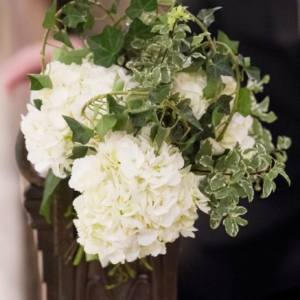 bouquets of white hydrangea, variegated pittosporum and looped ivy tendrils for Pew Markers at Wedding Ceremony kim starr wis