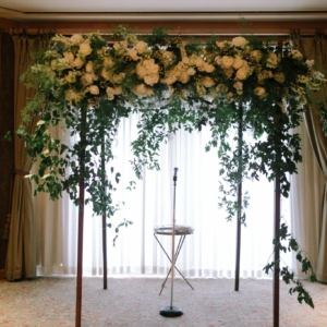 jewish wedding chuppah floral decor with vines and white flowers with the tallit layers on top dark wood chuppah built by kim starr wise floral events new orleans