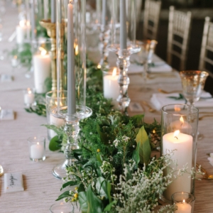 table garland at wedding reception of foliage garland with white floral accents by kim starr wise