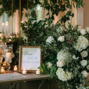 kim starr wise event florist use white flowers and lush greenery to decorate the welcome table at the wedding reception at marche in downtown new orleans