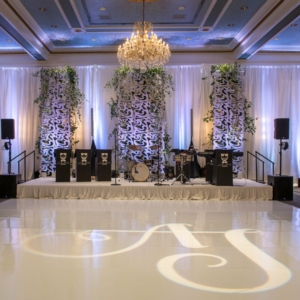 elegant wedding florals for january wedding in new orleans louisiana event florals by kim starr wise created dreamy romantic wedding reception stage backdrop with free-standing panels illuminated by backlighting and Pipe and Drape Backdrop