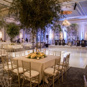elegant wedding florals for january wedding in new orleans louisiana event florals by kim starr wise created dreamy romantic wedding reception floral decor with large tree floral centerpieces decorated with dense florals on square tables decorated with dense florals at the base with votive candles
