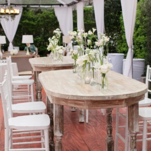 Pub table centerpieces at wedding reception in new orleans all pub tables had a collection of small bud vases in shades of white incorporating florals displayed in thin clear glass bud vases of varying heights by master wedding event florist kim starr wise