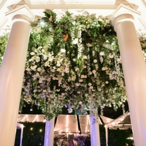 An inverted hanging garden built into the ceiling of the gazebo using all white and ivory flowers including hydrangea, spray roses, lilies, roses, tulips, stock, Italian ruscus, wild smilax, other flowers and green foliage while the vines will cascade down each of the columns designed and created by kim starr wise event florist in Louisiana