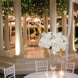 Centerpieces at outdoor wedding reception were repurposed from the aisle decor at the wedding ceremony large and medium white and ivory floral arrangements with garden roses, white hydrangea, ivory majolica spray roses, white polo roses by kim starr wise wedding and event florist