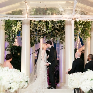 An inverted hanging garden built into the ceiling of the gazebo using all white and ivory flowers including hydrangea, spray roses, lilies, roses, tulips, stock, Italian ruscus, wild smilax, other flowers and green foliage while the vines will cascade down each of the columns designed and created by kim starr wise event florist in Louisiana