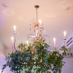 chandelier decorated with greenery at wedding reception in new orleans by kim starr wise floral events