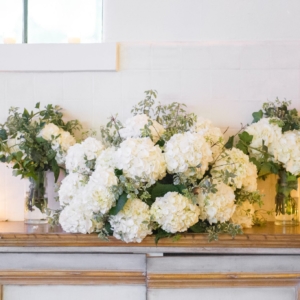 welcome table at wedding reception decorated with white hydrangeas and greenery in new orleans by kim starr wise floral event designer