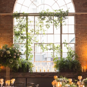 Lush dripping foliage arrangements along each window sill and each window was decorated with greenery and foliage of wild smilax décor accenting the panes, randomly and beautifully at new orleans louisiana wedding reception by best wedding florist in new orleans kim starr wise