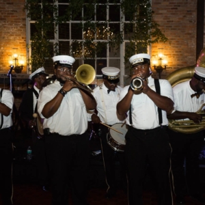 new orleans brass band at wedding reception plays in front of floral backdrop created by kim starr wise floral designer