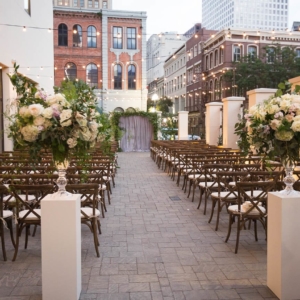 floral arrangements for the wedding ceremony included large arrangements on pedestals at the beginning of the aisle in a coordinating color palette of blush, mauve, grey, white, gold, beige and floral design style in clear glass Carol vase by kim starr wise event florist