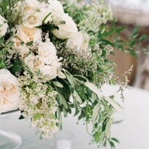 lush and beautiful arrangement in all white and ivory with draping foliage accents by kim starr wise floral events