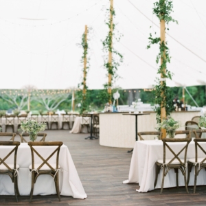 wedding reception tent poles decorated with smilax vines at mississippi gulf coast wedding in october by kim starr wise floral events