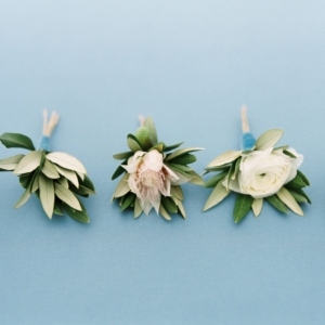 simple variety of tasteful green and white boutonnieres for the groomsmen and ushers at mississippi gulf coast wedding by kim starr wise white ranunculus boutonniere