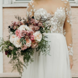 wild and asymmetric bridal bouquet with lots of movement and color palette to be pale pink mauve and green with touches of black flowers of scabiosa, ranunculus, roses, ruscus, thistle, and seasonal blooms and greenery for winter wedding in new orleans french quarter by kim starr wise wedding and event florist