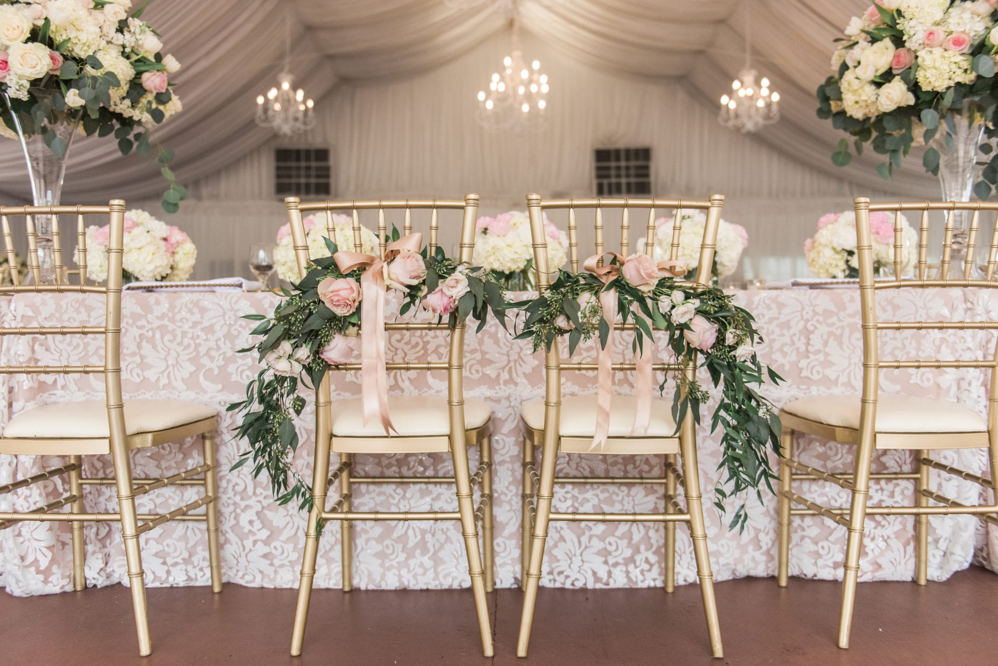 Wedding ceremony had a seated dinner, and the bride and groom's chairs were decorated with florals and greenery