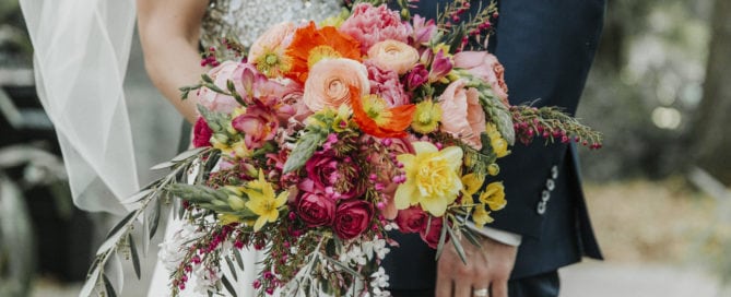 new orleans spring wedding floral arrangements kim starr wise bridal bouquet with a slight cascade in shades of fuchsia orange, peach, blush, and hints of yellow with greenery