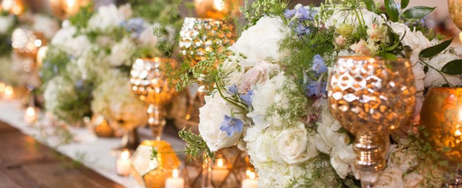 southern wedding reception decor by kim starr wise floral artist how to decorate farm tables for wedding reception using white, nude, beige, blush and pale blue color palate of low lush gold compote, filled with a lush and wild centerpieces in white, nude, beige, blush and pale blue flowers and lots of vines using hydrangea, roses, lisianthus, garden roses, spray roses, peonies, Italian ruscus, queen anne’s lace, tweedia